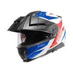 Schuberth öppningsbar MC-hjälm E2 Explorer i blå och röd design, visir nedfällt, sidovy. Perfekt för säker motorcykelkörning.